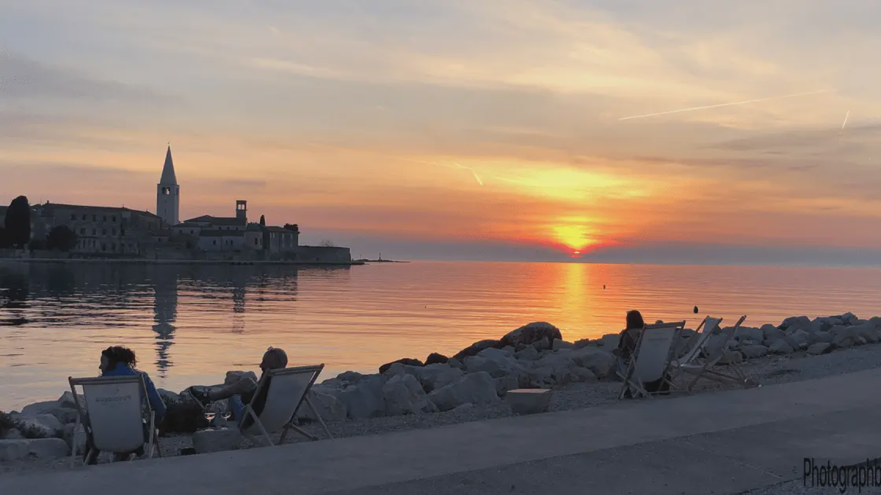 Sunset over Poreč harbor with boats and historic buildings